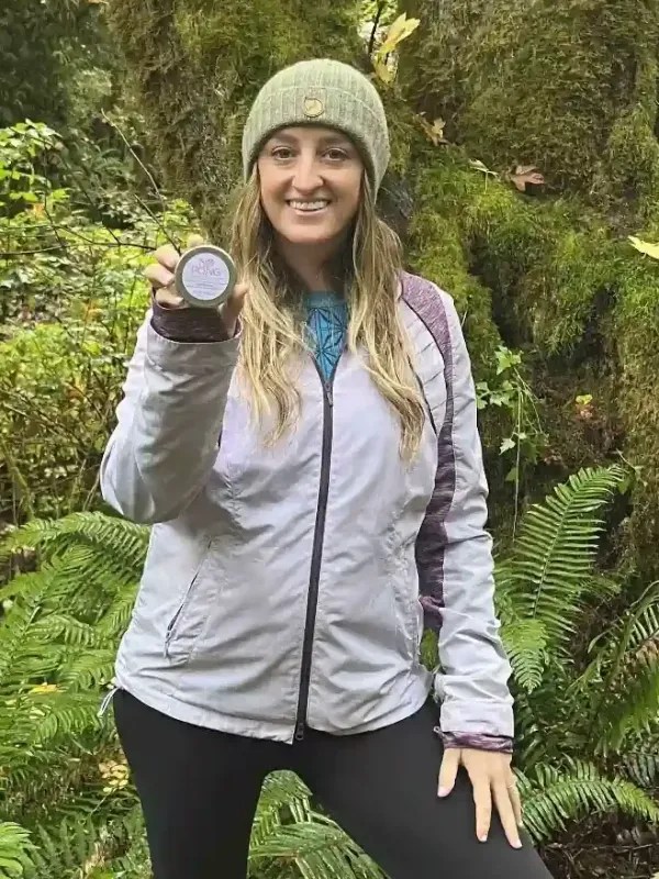 A No Pong customer on a forest trail holding up her tin